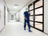 Een chirurg van het HIN loopt door de gang. 